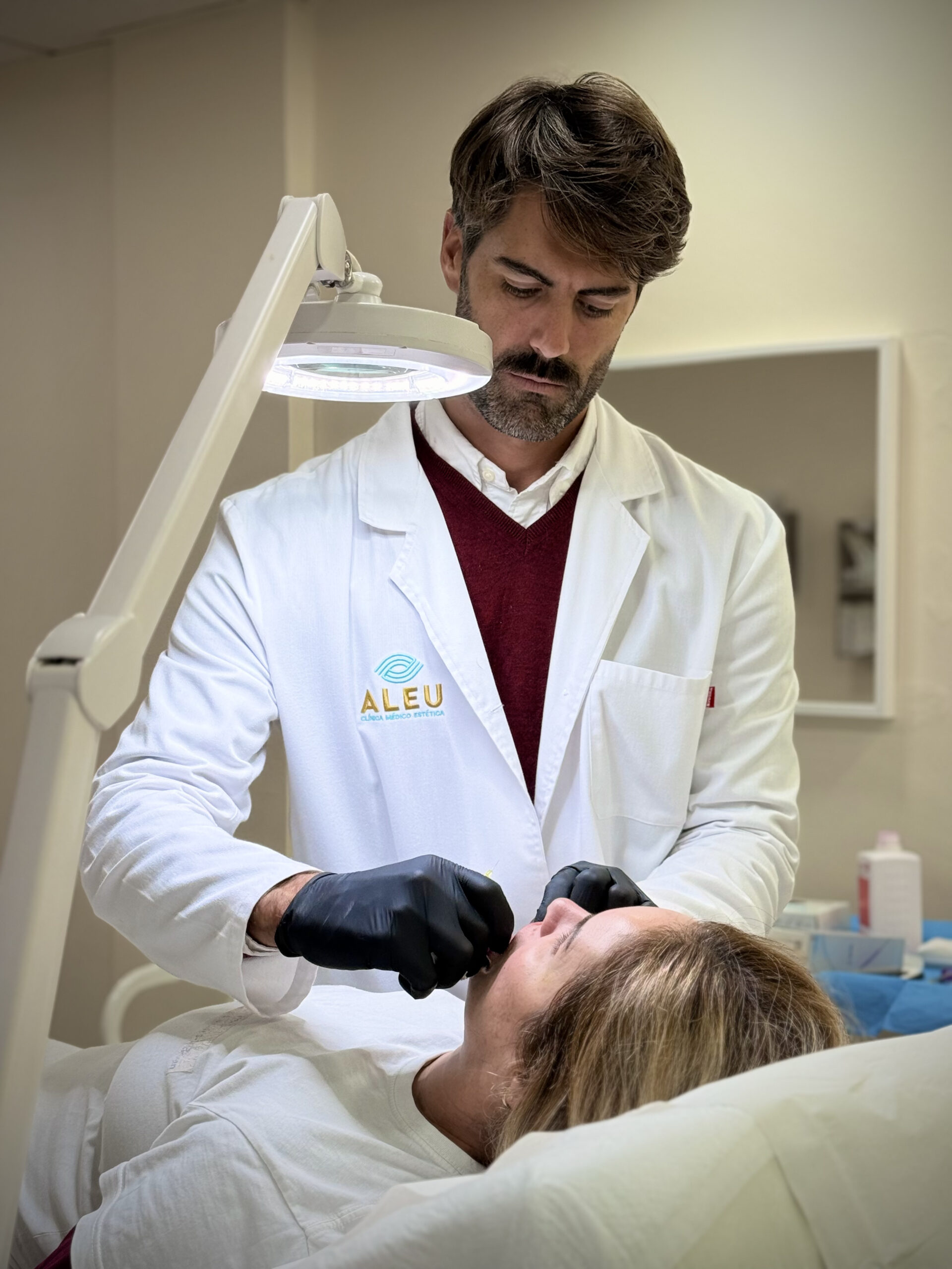 Profesional de medicina estética realizando un tratamiento en consulta en Clínica Aleu.